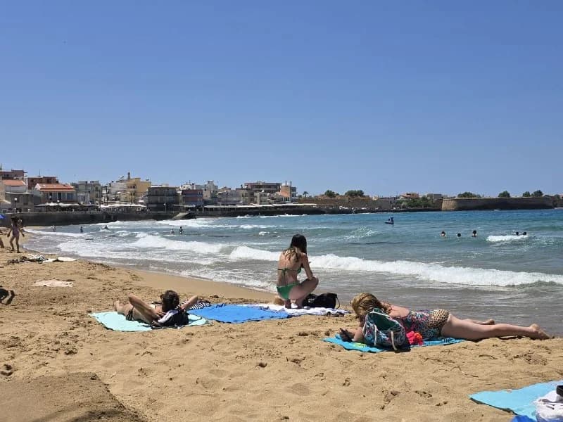 People enjoying a bright beach beside calm blue water