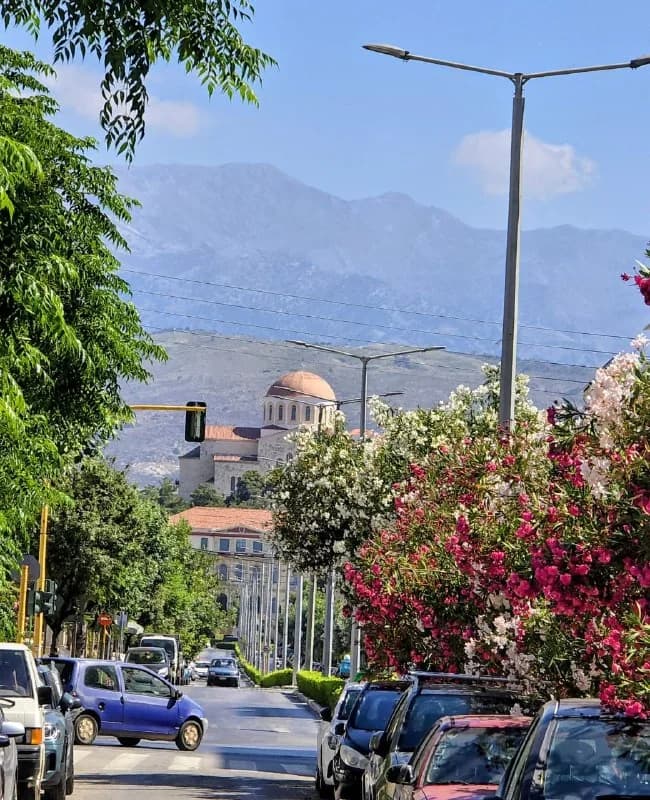 A domed chapel framed by flowers and distant mountains