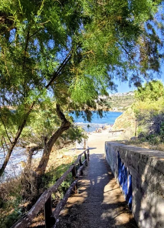 A shaded garden path leading toward the sea