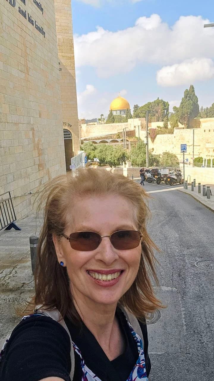Margaret smiling with the golden Dome of the Rock visible in the distance