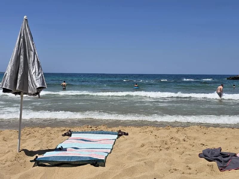 A quiet beach with folded loungers facing the sea