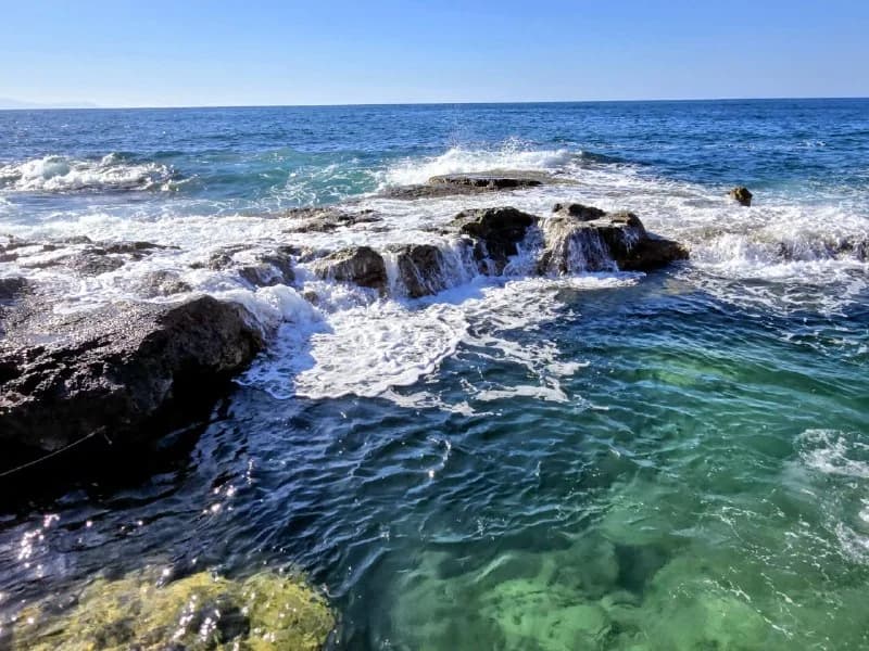 White waves moving through dark coastal rocks