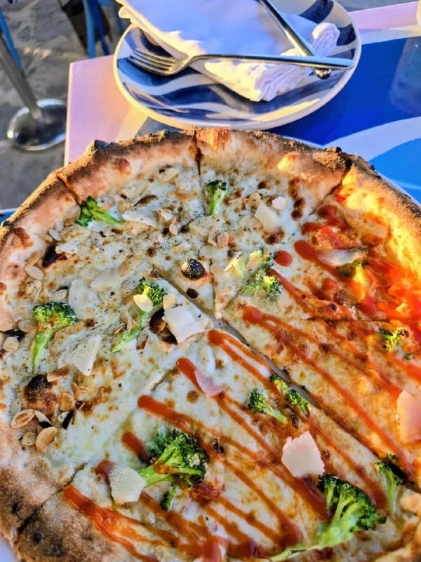 A freshly baked vegetable pizza at a travel table